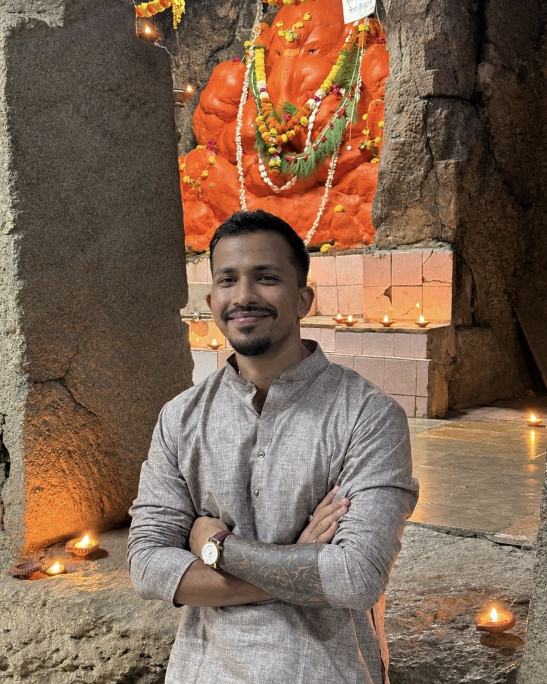 Ninad smiling in a lamp-lit Ganesh cave temple